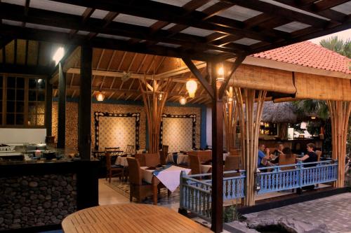 un restaurante con mesas en un patio en Mans Cottages & Spa, en Pemuteran