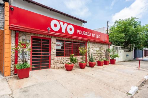 a restaurant with a red sign on the side of a building at OYO Pousada Tia Léo Campinas in Campinas