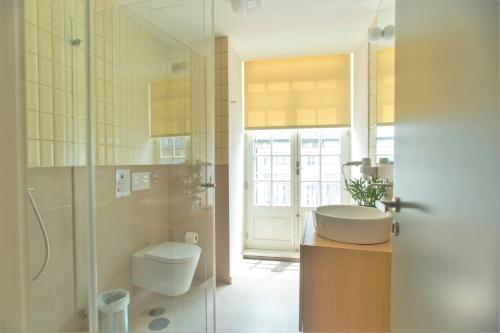 a bathroom with a sink and a toilet and a shower at Clérigos Prime Suites by Porto City Hosts in Porto