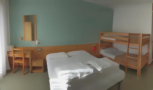 a bedroom with a bunk bed and a desk at Sport & Family Hotel Bucaneve in Brentonico