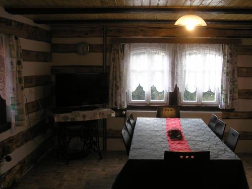 a dining room with a table and a flat screen tv at Chalupa Erika in Dobšín