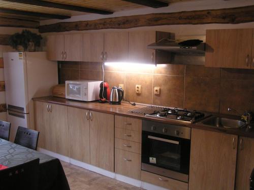 a kitchen with wooden cabinets and a stove top oven at Chalupa Erika in Dobšín