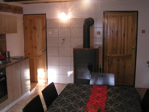 a kitchen with a stove and a table in a room at Chalupa Erika in Dobšín