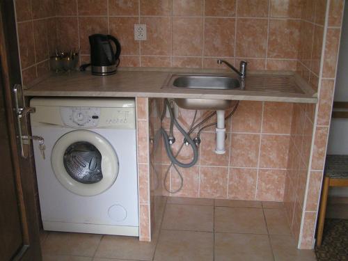a kitchen with a sink and a washing machine at Chalupa Erika in Dobšín