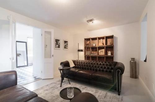 a living room with a leather couch and a table at L'Hotel Particulier Griffintown in Montréal