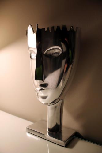 une sculpture métallique d'une tête sur un support dans l'établissement A La Fleur d Oranger - Lille La Madeleine, à La Madeleine