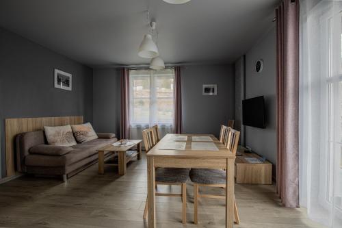 ein Wohnzimmer mit einem Tisch und einem Sofa in der Unterkunft Apartamenty Villa Mountain View in Szklarska Poręba