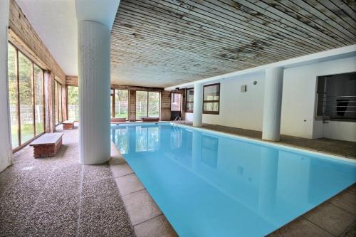 une grande piscine avec de l'eau bleue dans un immeuble dans l'établissement APPARTEMENT AVCE ACCES PISCINE-WIFI-SAINT JEAN D'AULPS STATION-4 PERSONNES-DAILLE S18, à Saint-Jean-dʼAulps