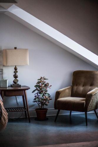 a living room with a chair and a table at L'Hotel Particulier Griffintown in Montréal