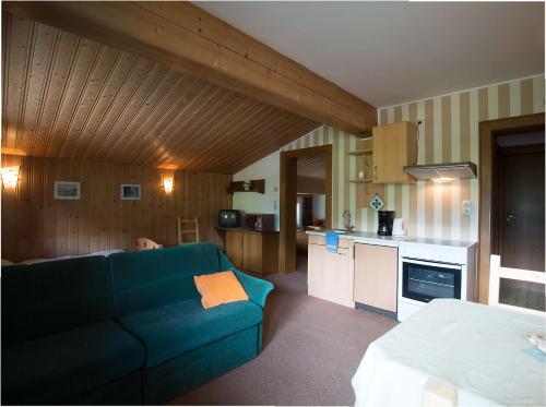 a living room with a blue couch and a kitchen at Haus Brandeck in Uttendorf