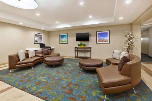 a waiting room with couches and chairs and a flat screen tv at Candlewood Suites Washington North by IHG in Washington