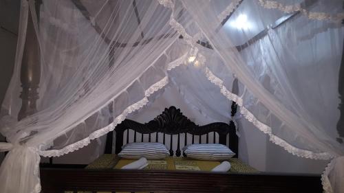 a bedroom with a bed with a canopy at Samudra Guest House in Mirissa