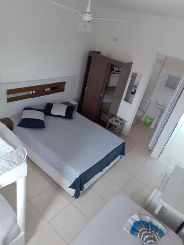 ein Schlafzimmer mit einem Bett in einem weißen Raum in der Unterkunft Colônia de Férias SITRAEMFA in Peruíbe