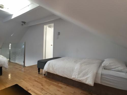 a white bedroom with a bed and a window at L'Hotel Particulier Griffintown in Montréal