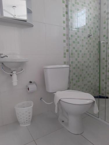 ein Badezimmer mit Toilette und Glasdusche in der Unterkunft Colônia de Férias SITRAEMFA in Peruíbe