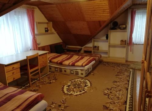 a bedroom with two beds and a desk in a attic at Chata Hrádok in Liptovský Hrádok