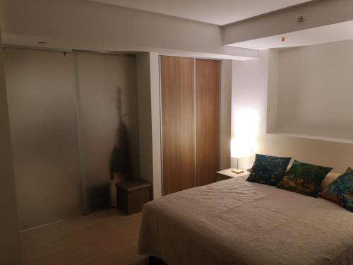 a bedroom with a bed and a lamp on a table at El mejor apartamento en excelente ubicación. in San José
