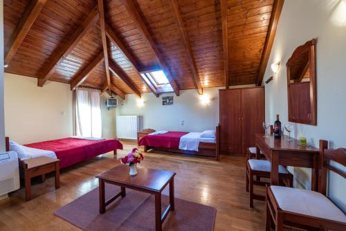 a large room with two beds and a table at Xenonas Kypseli in Kipseli