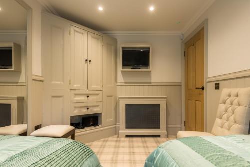 a bedroom with a bed and a fireplace and a tv at Crossbasket Castle, Hotel & Restaurant in High Blantyre