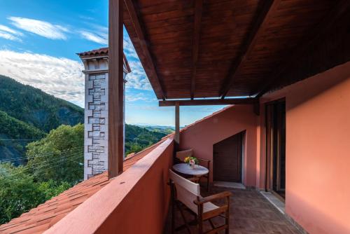 a balcony with a table and a view of the mountains at Xenonas Kypseli in Kipseli