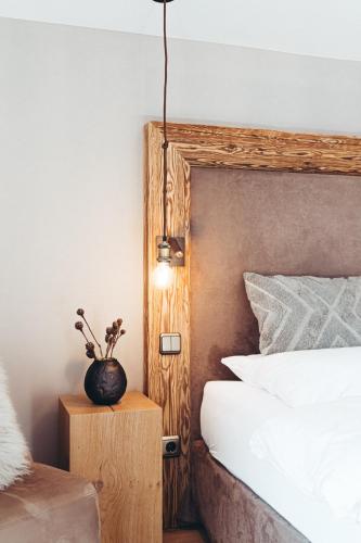a bedroom with a bed and a vase on a night stand at Designhotel Sonnhof by Vitus Winkler in Sankt Veit im Pongau
