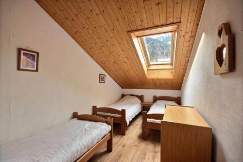 a room with two beds and a window at DUPLEX AVEC ACCES PISCINE - SAINT JEAN D'AULPS STATION - 9 PERSONNES - DAILLE D10 in Saint-Jean-dʼAulps