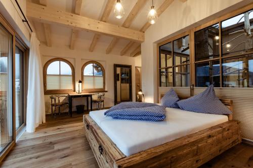 a bedroom with a large bed with blue pillows at Flora - Das kleine Gartenhotel in Ellmau