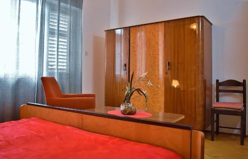 a bedroom with a bed and a table and a chair at Apartman Balen J. in Banjol