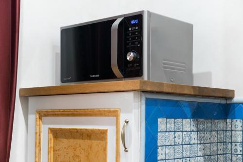 a microwave on top of a kitchen cabinet at THE IMPERIAL SUITE e THE BRICKS in Rome