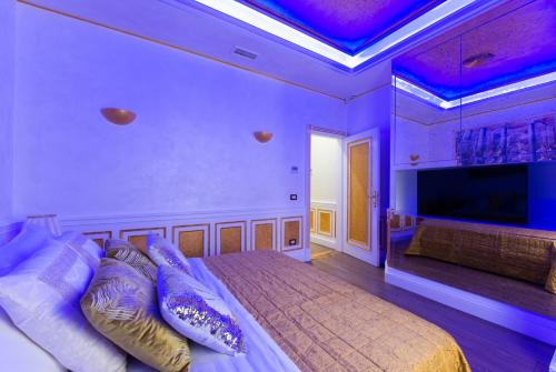 a bedroom with a large bed with purple lighting at THE IMPERIAL SUITE e THE BRICKS in Rome