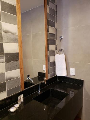 a bathroom with a black sink and a mirror at Pousada Ricoco in São Miguel dos Milagres