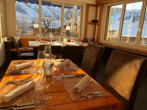 a dining room with a table with wine glasses at Mountain Lodge Sedrun in Sedrun