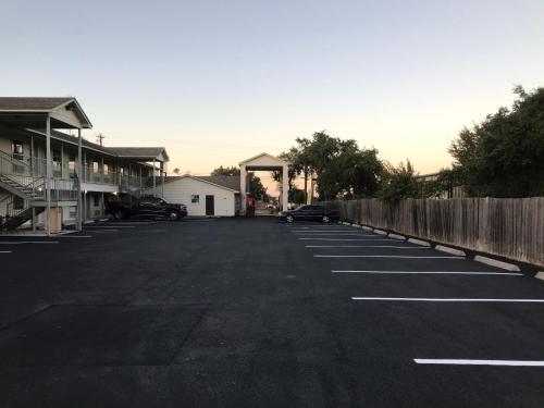 an empty parking lot with a fence and a building at Cedar Creek Inn in Bertram