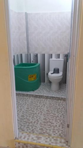bagno con servizi igienici e cestino verde di Hotel Surya Utama - Syariah a Probolinggo