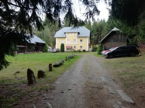 a dirt road in front of a yellow house at Penzion Rudolfovna in Železná Ruda