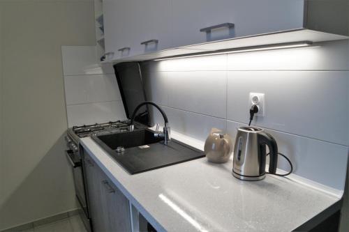a kitchen counter with a sink and a stove at Apartamencik w centrum in Rumia