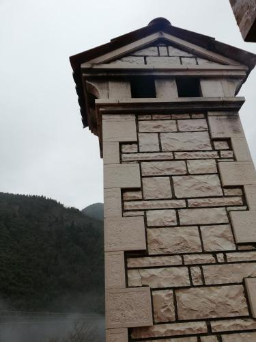 a stone tower with a view of a lake at Xenonas Kypseli in Kipseli