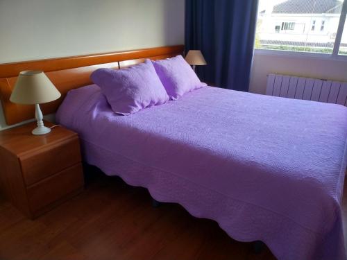 a bedroom with a purple bed and a window at Residencial Playa Lisa in Boadilla del Monte