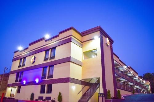 a building with lights on top of it at Super 8 by Wyndham Raleigh Downtown in Raleigh