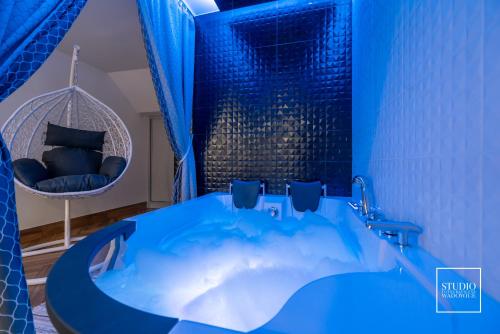 niebieska wanna w pokoju z krzesłem w obiekcie Exclusive Apartment Centrum w Wadowicach