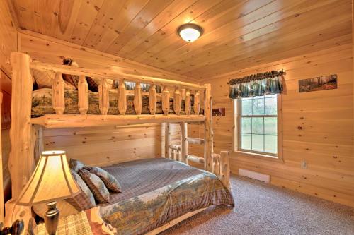 a bedroom with bunk beds in a log cabin at Rustic Benezette Cabin with Porch, Hot Tub and Fire Pit in Benezette