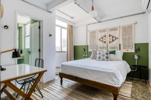 een slaapkamer met een bed, een bureau en een tafel bij Selina Aurora Sao Paulo in Sao Paulo
