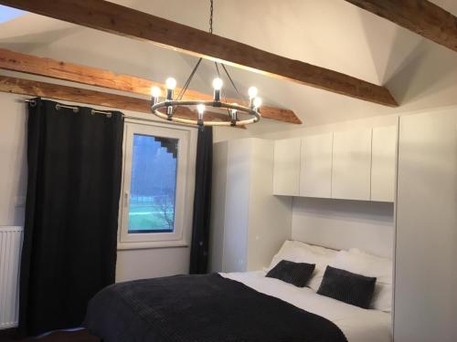 1 dormitorio con cama y lámpara de araña en Kasita Bled Apartments en Bled