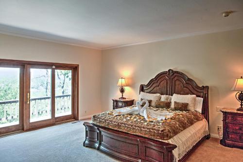 Un dormitorio con una cama grande y una ventana grande. en Lake Arrowhead House with Lake Views and Wet Bar!, en Lake Arrowhead