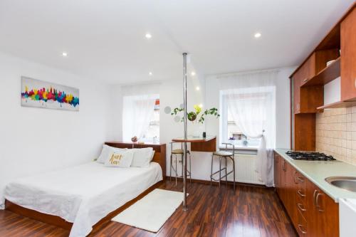 ein kleines Schlafzimmer mit einem Bett und einer Küche in der Unterkunft Apartment Ruska 12 in Lwiw