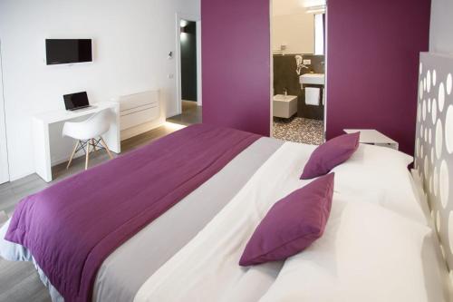 マテーラにあるDimora Mefite-Camere con Bagno Privato e Self check-inの紫と白のベッドルーム(大型ベッド1台付)