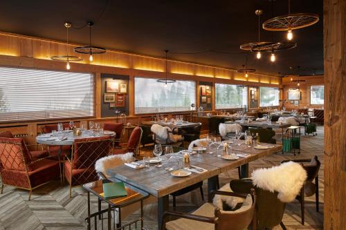 a restaurant with tables and chairs in a room at Chalet Alpen Valley, Mont-Blanc in Combloux