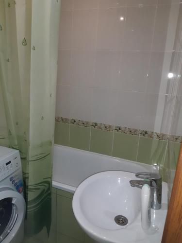 bagno con lavandino bianco e lavatrice di Аппартаменты на Бутырина a Kremenčuk