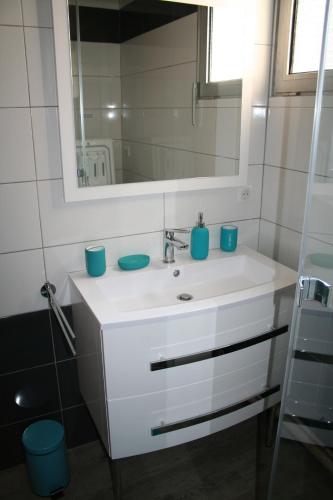 une salle de bain avec un lavabo blanc et un miroir dans l'établissement Aux quatre saisons du Cabaliros, à Argelès-Gazost