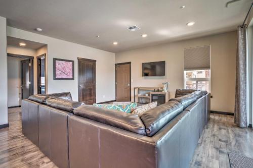 a large brown leather couch in a living room at Modern Manson Condo with Pool and Lake Chelan Views! in Manson